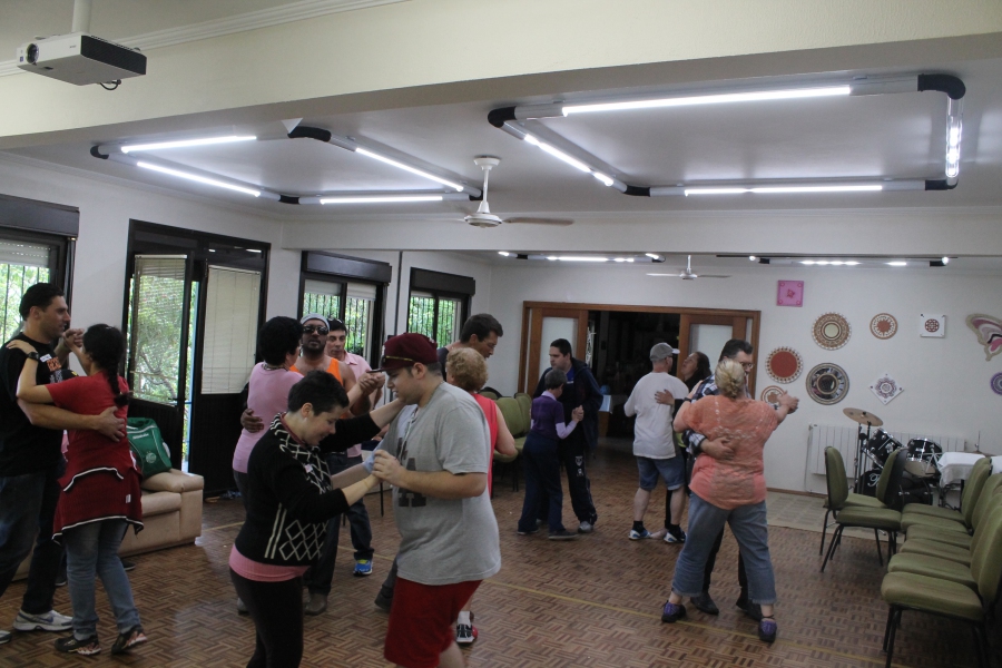 Grupo de usuários adultos se divertindo durante ensaio na oficina de dança.